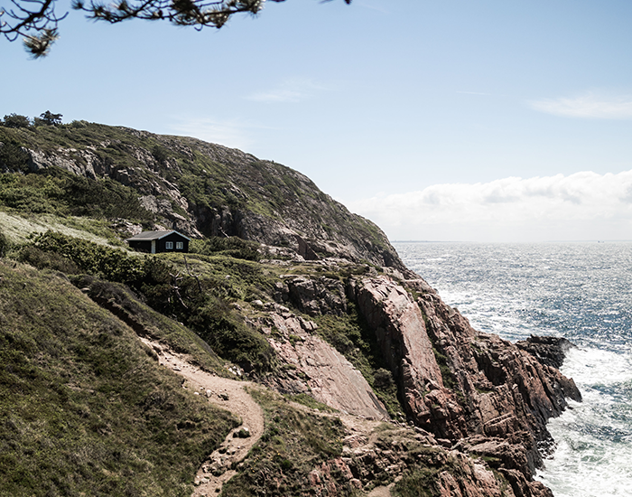 En malerisk udsigt over naturen med klippeskrænter og havet.
