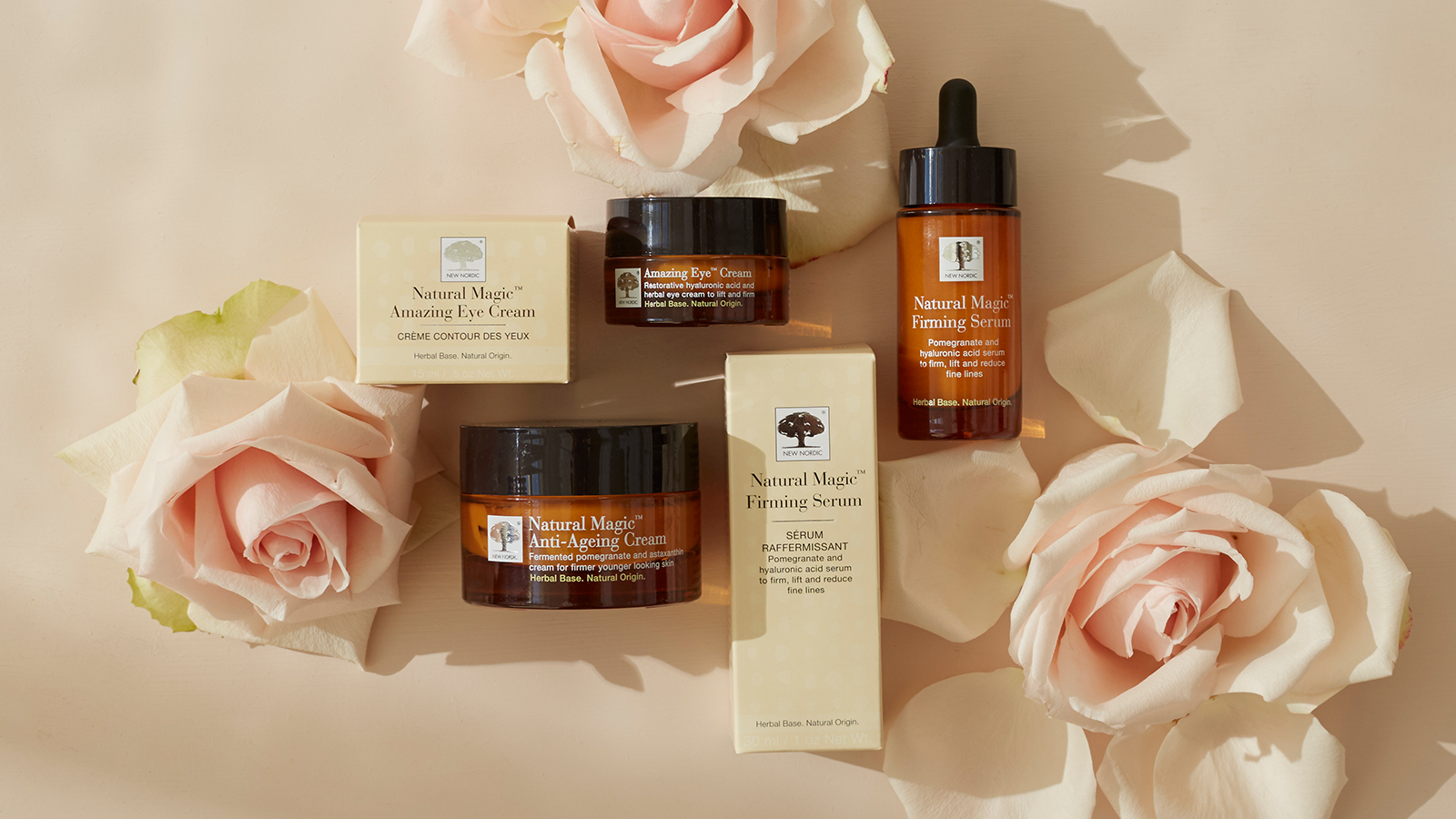 Natural Magic™ hudplejeserie med Amazing Eye Cream, Firming Serum og Anti-Ageing Cream omgivet af lyserøde roser.